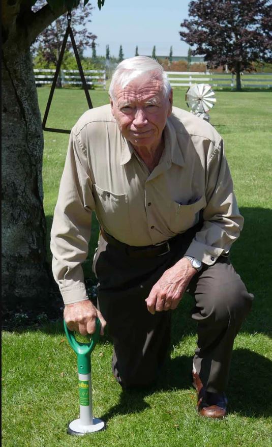 easy riser being used by and older gentlemen kneeling on grass outside under the shade of a big tree